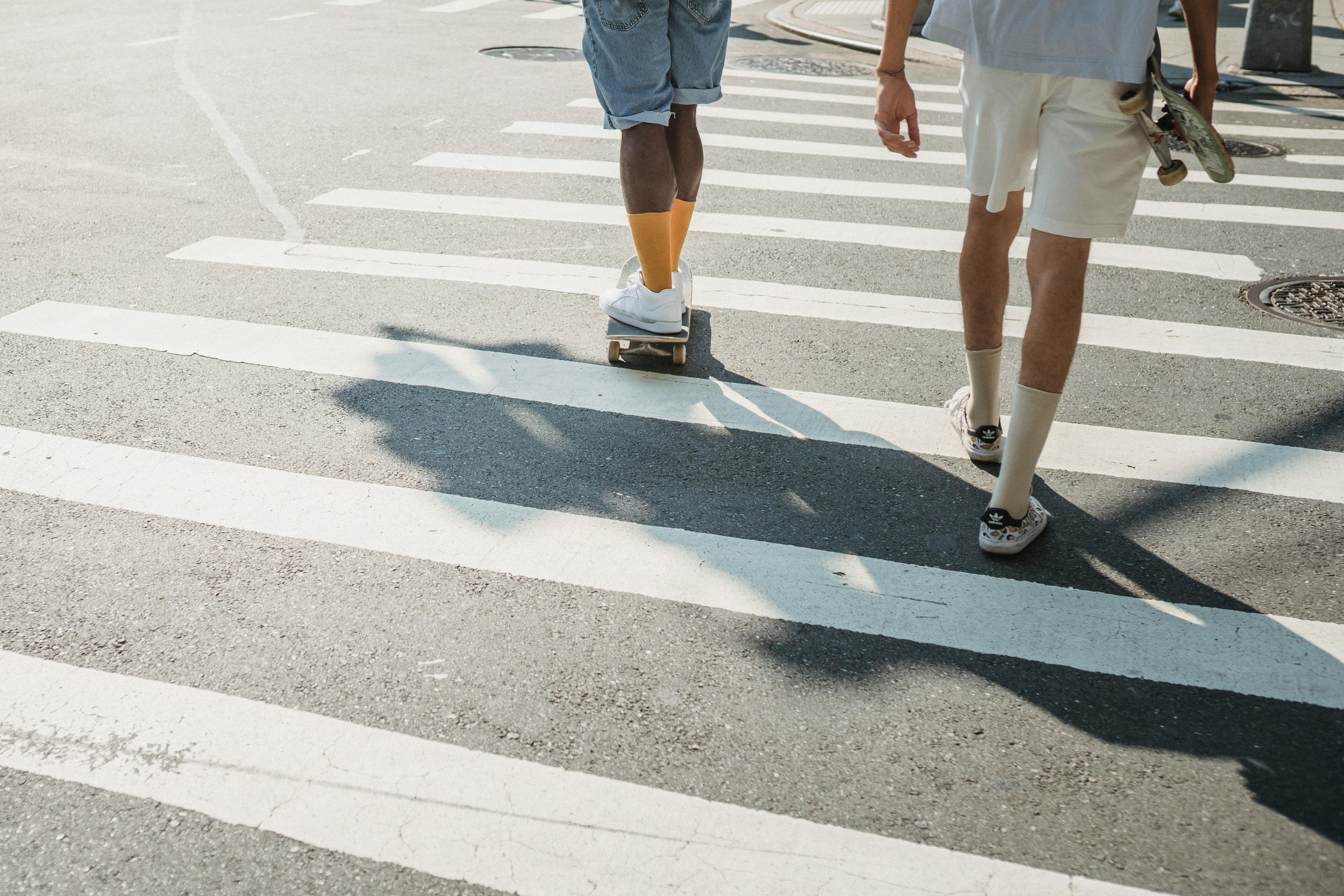 Gruppe mit Skateboard überquert einen Zebrastreifen